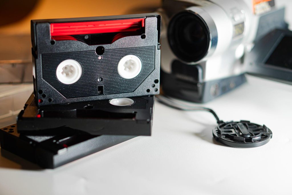 Stack of VHS tapes near old video camera.