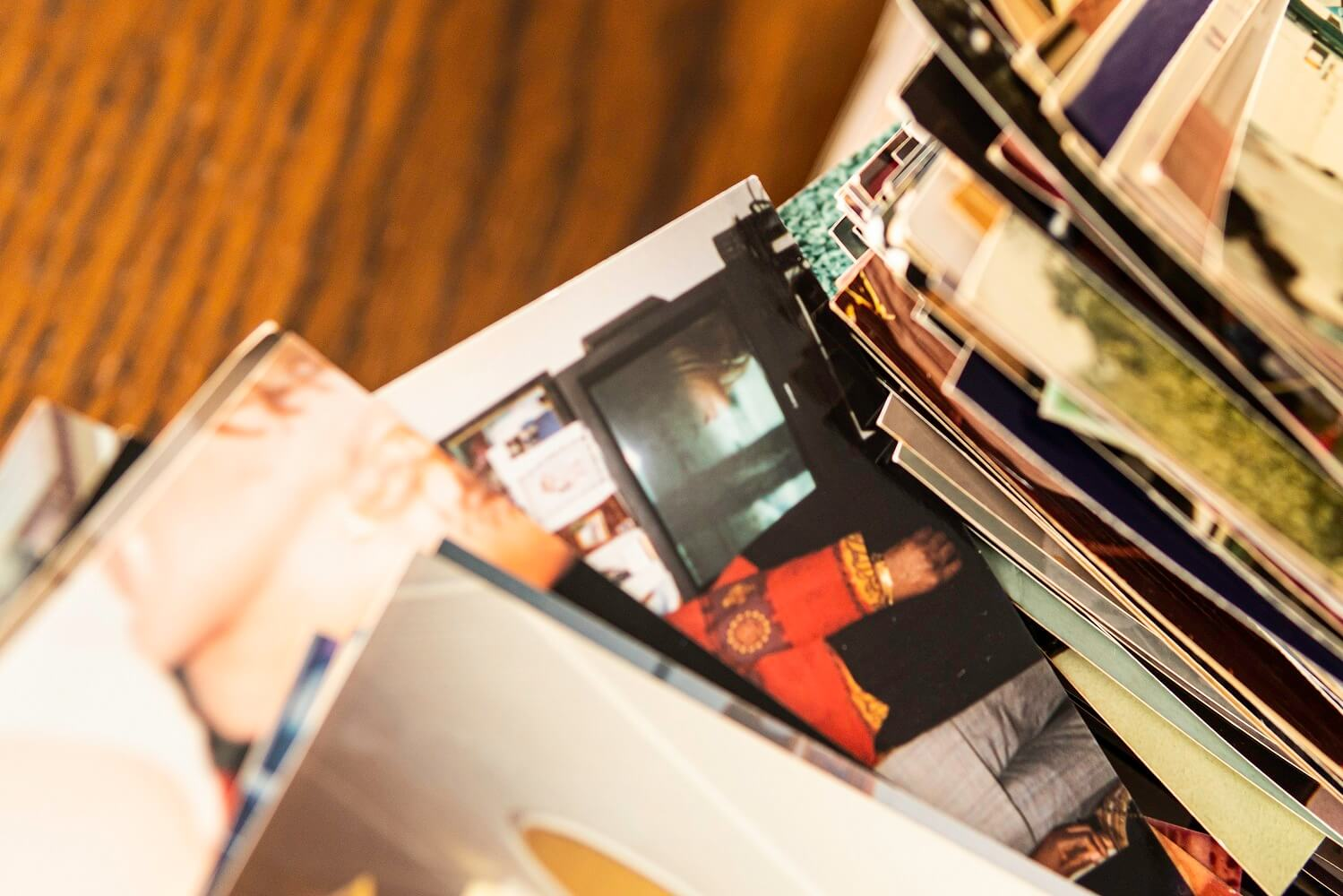 Stack of printed photographs on wooden table