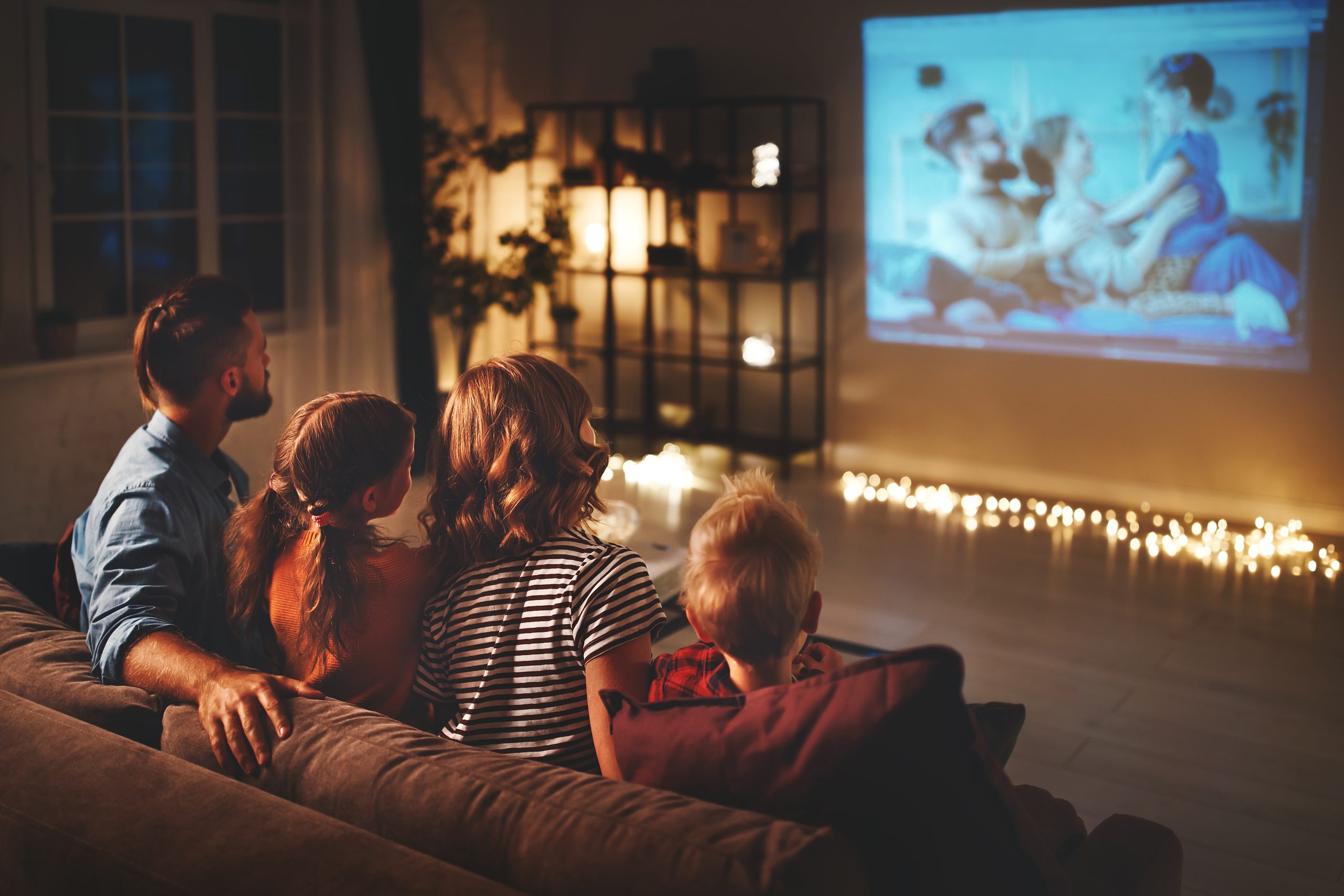Family watching movie on home projector screen.